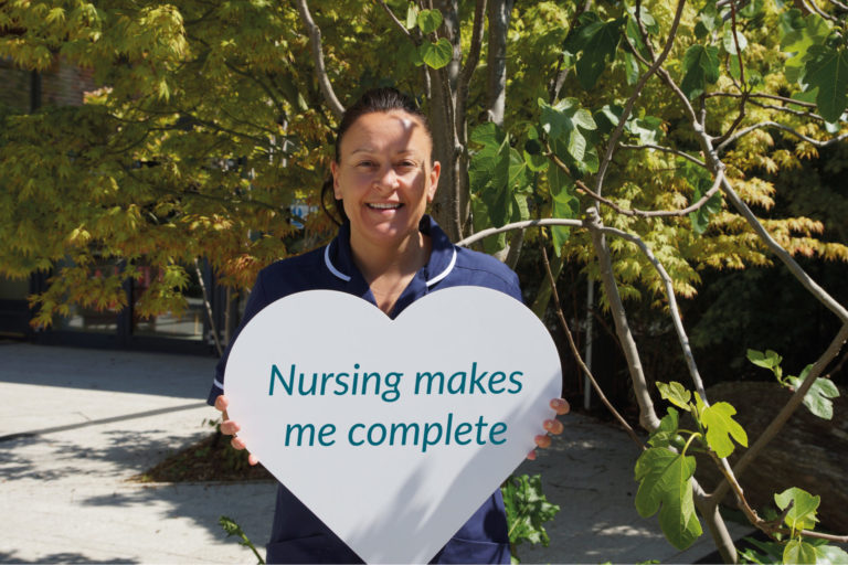 Nurse holding a sign saying: Nursing makes me complete
