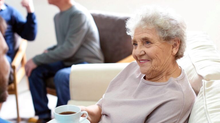 Older woman being given a cup of coffee