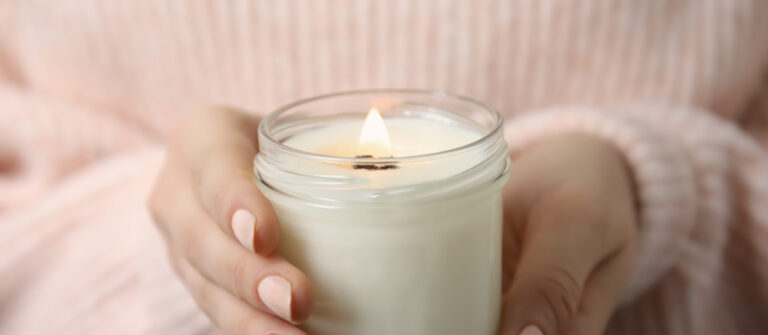 A close up of hands holding a candle