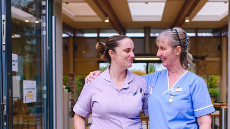 Image of a smiling nurses outside the hospice