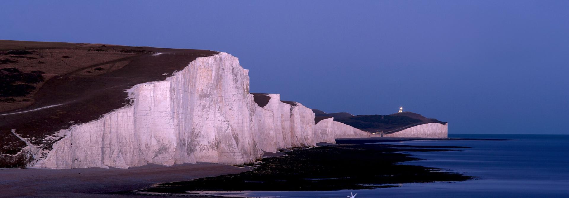View of the white chalk cliffs of the Seven Sisters in the South Downs National Park at dawn.
