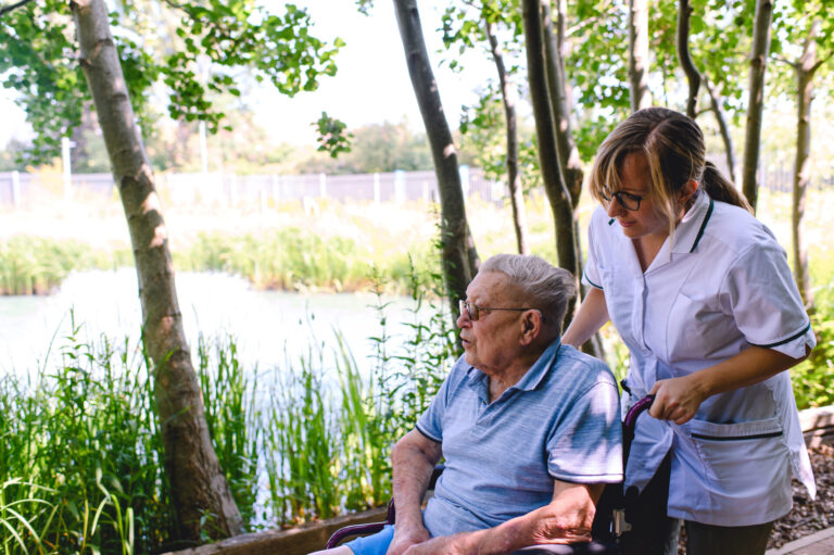 A patient and member of staff outside the hospice in the gardens.