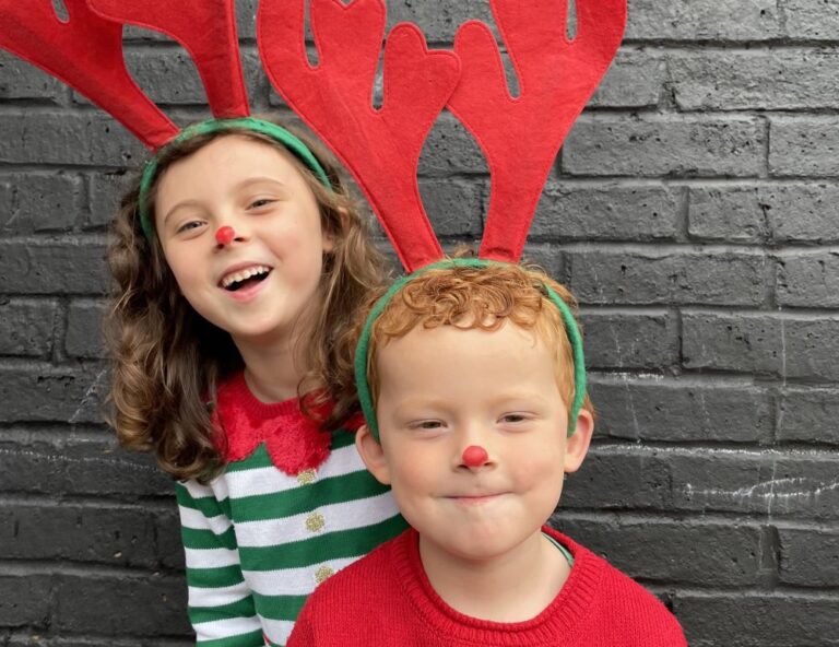 Two children with red noses and Reindeer antlers.