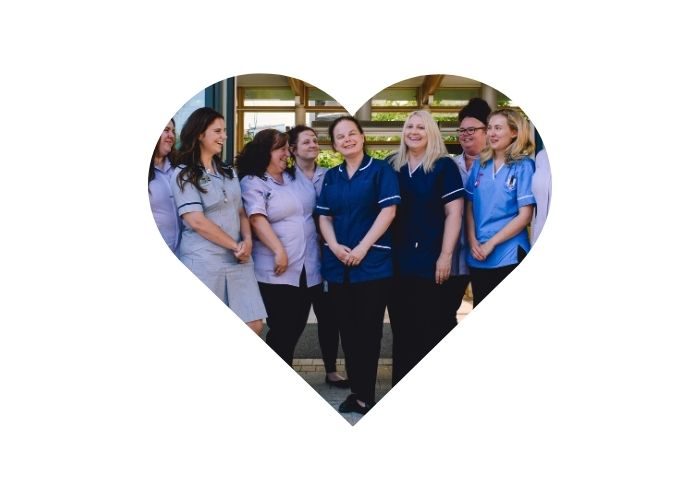 A team of nurses and healthcare assistants in a heart graphic.