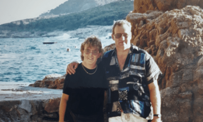A couple posed in front of the sea