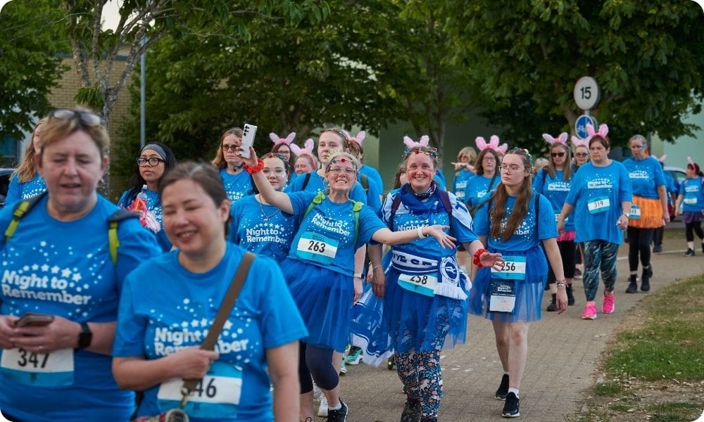 A big group pf walkers taking part in Night to Remember wearing blue branded shirts