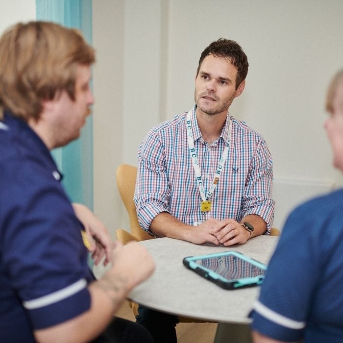 CEO Stuart Palma sits with clinical colleagues at one of Southern Hospice Group's hospices