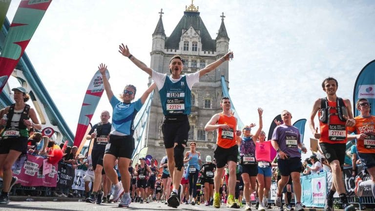 A runner raises his arms as he crosses Tower Bridge in the London Marathon 2026