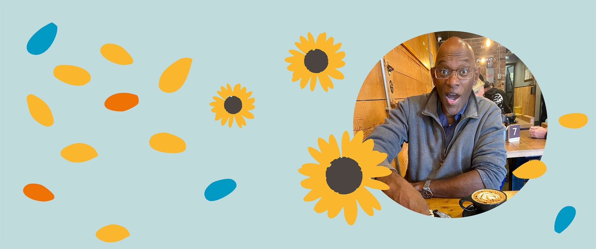 Derrick in a cafe making a face at the camera. The image is surrounded by graphics of sunflowers and multicoloured petals