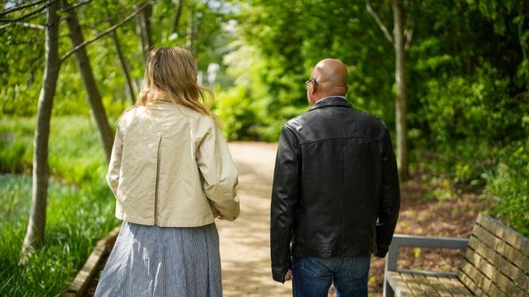 two people walking along a path in the St barnabas House garden. They are in conversation