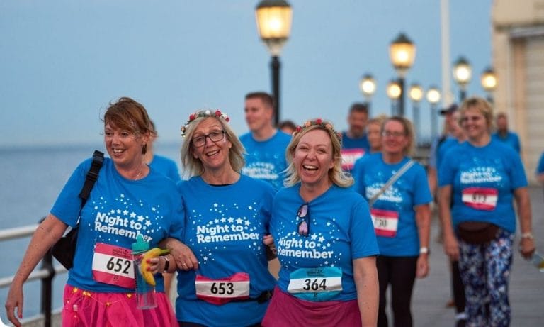 People walk in blue t-shits for a hospice charity