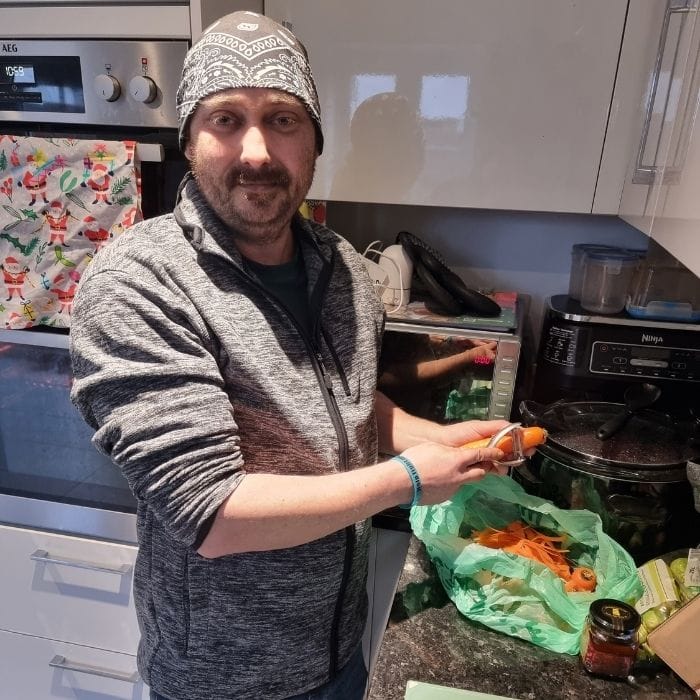 Dan peeling a carrot in the kitchen