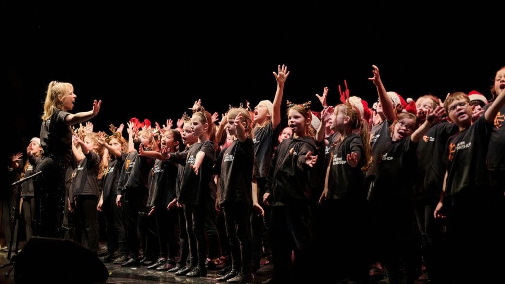 Group of school children singing on a stage